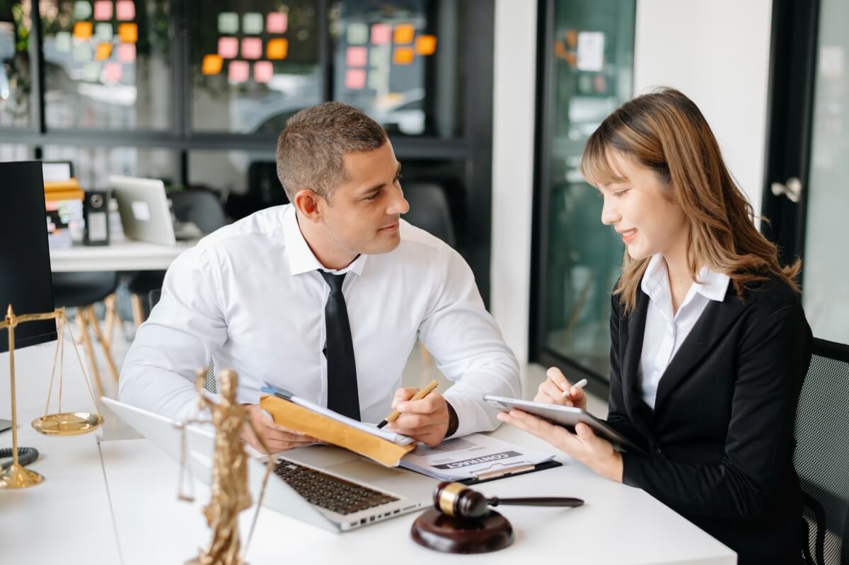 Doradca restrukturyzacyjny omawia strategię z klientką przy biurku.